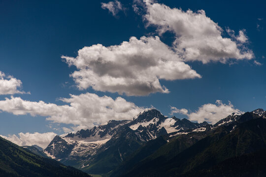 thick clouds over the snowy summits of a mountain range