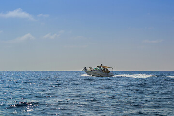 Obraz premium yacht in the sea with people off the coast of Budva at sunset