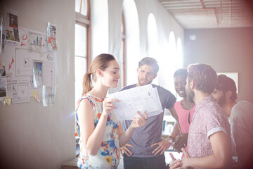 Casual business people reviewing paperwork in meeting in office