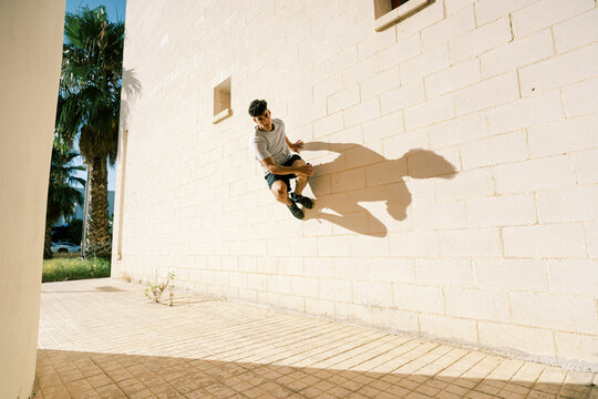Sporty man doing parkour trick on street
