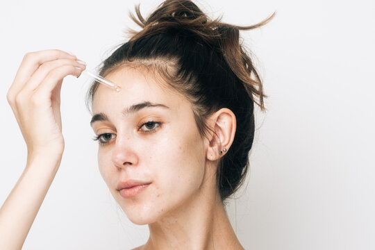 Woman Using Face Serum With A Dropper Studio Shot