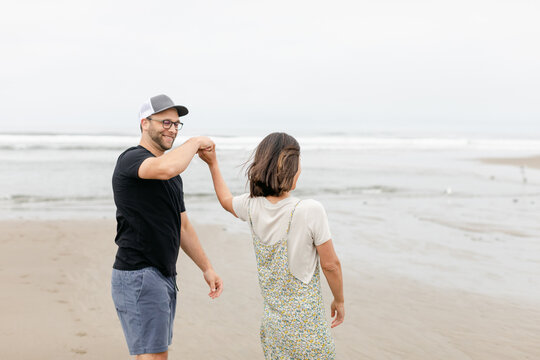 A Married Couple Dance on the Beach Playfully