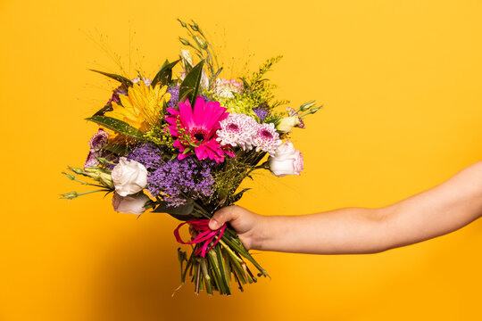 Hands of a girl holding a bouquet of flowers