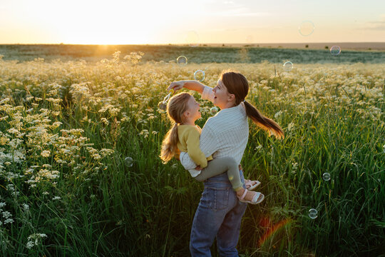 Mother and daughter playing together in meadow