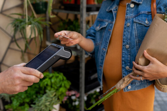 Woman paying with her credit card at flower shop