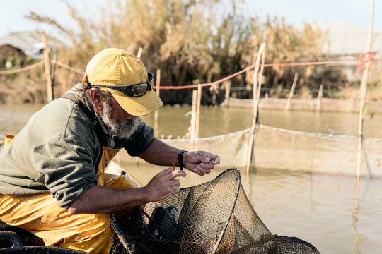 Close-up of a fisherman fixing his fishing net with rope