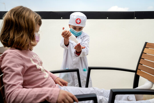 Brother and sister playing doctor while he disinfects his hands