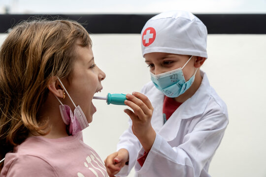 Little brother playing doctor checking his patient sister's mouth