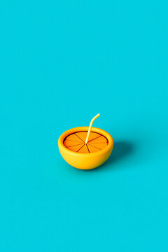 3D render of an orange with a straw on blue background