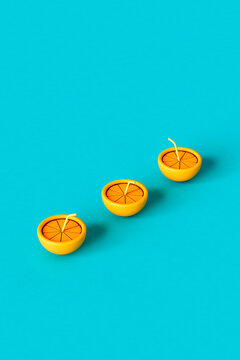 3D render of 3 oranges with a straw on blue background