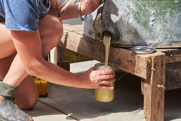 Beekeeper pouring fresh raw honey