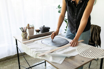 Handmade pottery workflow. Woman making ceramic plate. 