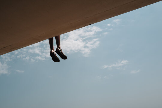 Feet hanging over promenade at Hastings