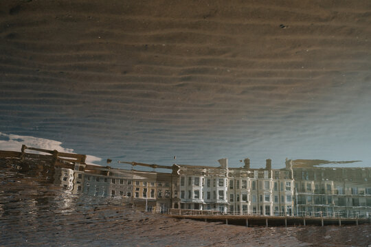 Reflection of buildings in water at beach of Hastings, East Sussex