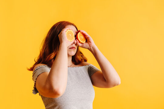 Woman with oranges over her eyes