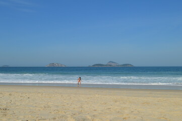 Fototapeta na wymiar Criança brincando na praia de Ipanema, Rio de janeiro brazil