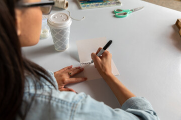 Woman Writes Thank You in Card