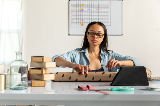 Woman Works on Gift Wrapping in Home Office