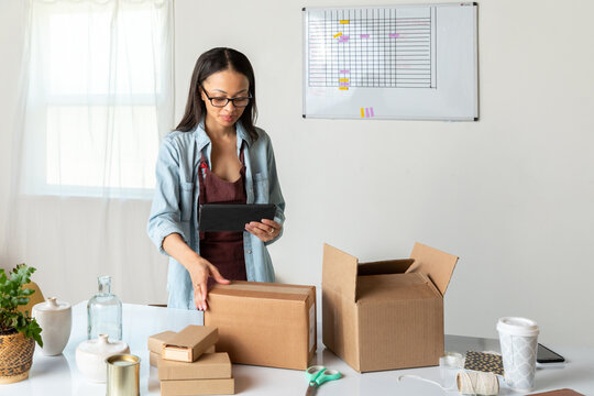 Woman Places Boxes on Table in Office