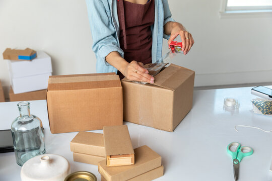 Woman Seals Cardboard Box