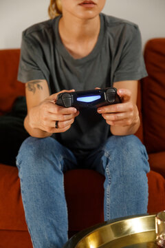 Unrecognizable woman using contemporary controller on sofa