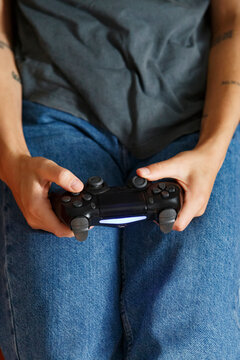 Crop gamer pressing button and stick on gamepad