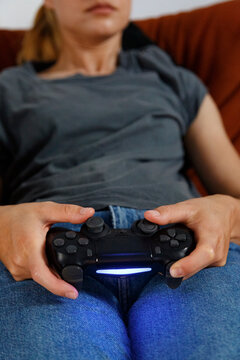Unrecognizable relaxed woman playing videogame on couch