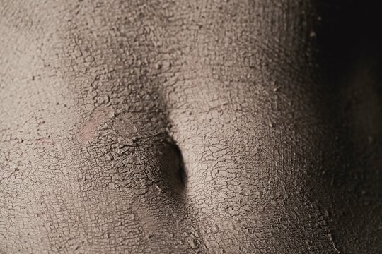 anonymous naked young woman with organic clay mask