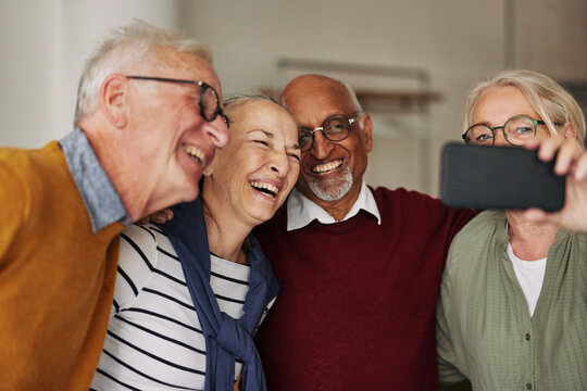Laughing Group Of Seniors Taking Selfies