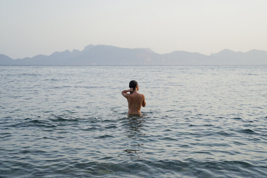 Woman swimming naked in the sea on a summer morning 