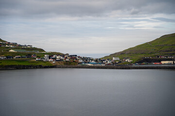 Fototapeta na wymiar Beautiful aerial view of the town of Miovagur in the Faroe Islands, with its :churchs, grass roofs and colorful Houses in front of the ocean 