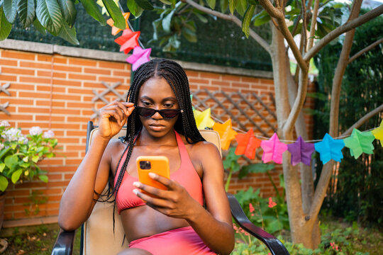 Black Girl With Sunglasses Checking The Phone At Home.