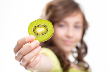 Young girl holding up a slice of fresh kiwi fruit