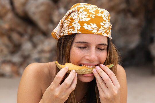 Relaxed female having melon on beach