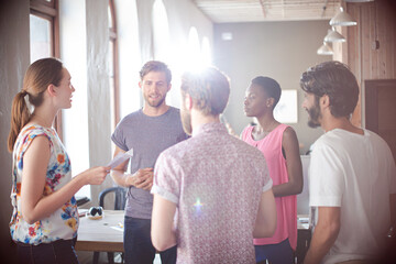 Naklejka premium Casual business people meeting in circle in sunny office