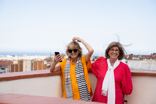 Senior friends having fun on rooftop with city views