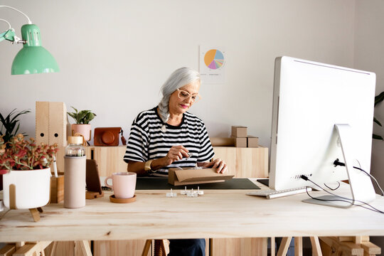 Senior woman packing an online store order
