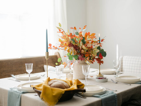 Fall decor table setting with foraged leaves and fresh bread