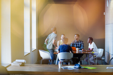Creative business people working at tables in sunny office