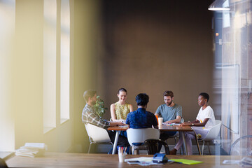 Casual business people working at tables in open office