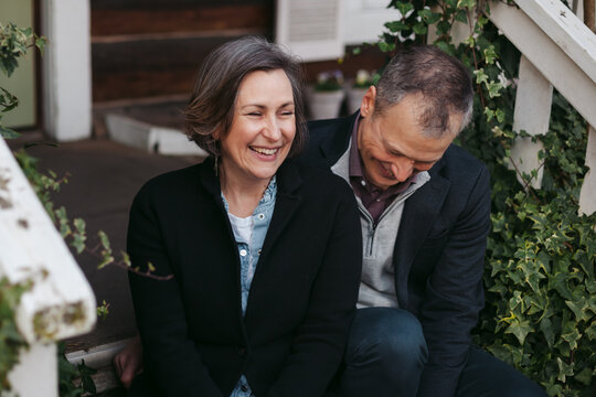 Happy middle age couple talking on steps.