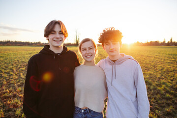 Three young adults / teens outside together.