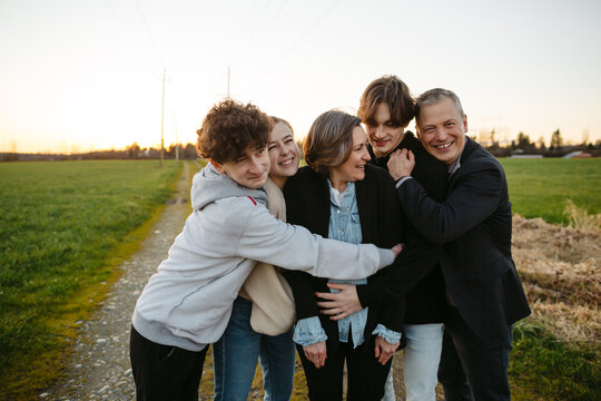 Fun loving family hugging together outside.