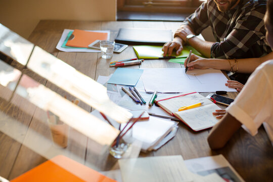 Creative Business People Reviewing Paperwork In Sunny Office