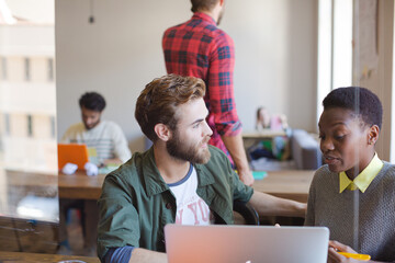 Creative business people working at laptop in office