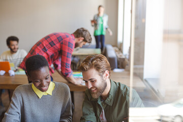 Creative business people working at laptop in office