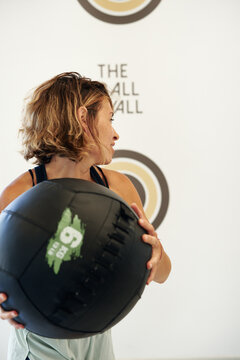 Motivated female athlete throwing heavy med ball