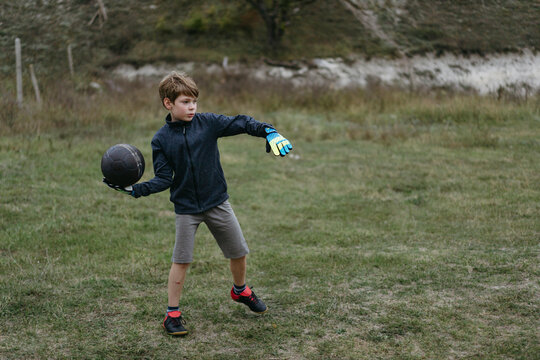 Kid plays football in the backyard.
