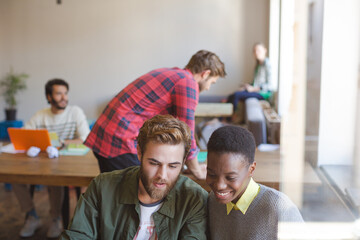 Creative business people working at laptop in office