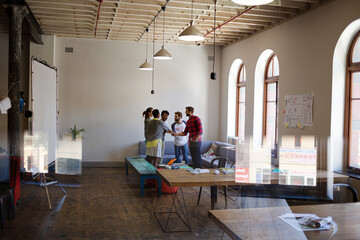Casual business people joining hands in meeting in office